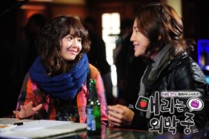 Two people smiling at bar table with drinks