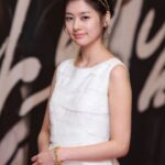 Smiling young woman in white dress