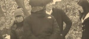 Four people conversing outdoors in autumn