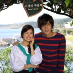 Smiling young couple under Love's Lock sign