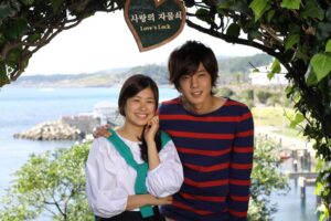Smiling young couple under Love's Lock sign