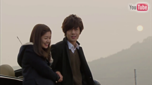 Young couple smiling outdoors at sunset