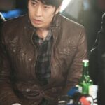man in brown leather jacket holding tissue
