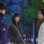 Three people standing on a nighttime city street