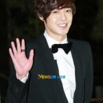 Smiling man in tuxedo waving hand