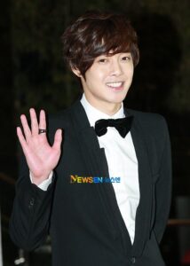 Smiling man in tuxedo waving hand