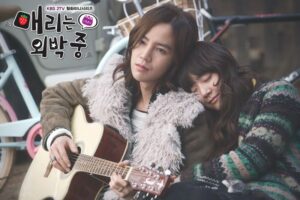 Man plays guitar while woman rests on shoulder