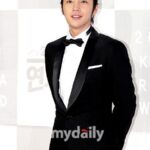 Man in black tuxedo smiling at event