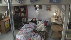 Two people cuddled on bed in cozy loft