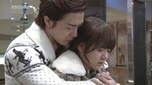 Man comforting crying woman in embrace