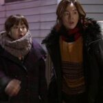 Two surprised people in winter coats outdoors