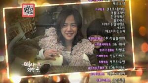 Two people on couch with guitar and credits