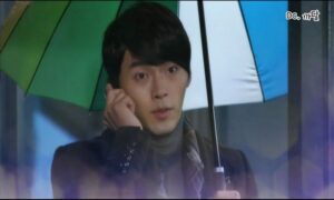 Man holding multicolored umbrella talking on phone