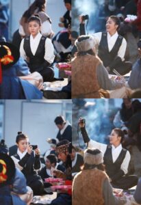 Woman in period costume photographing communal meal