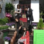 Four people on steps with guitar case