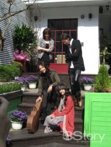 Four people on steps with guitar case
