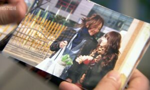 Hands holding photo of two smiling people
