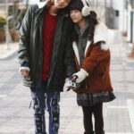 Two people in winter coats on sidewalk