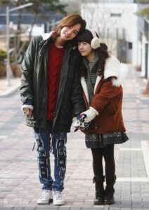 Two people in winter coats on sidewalk