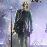 Long-haired singer on smoky stage with microphone