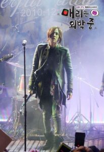 Long-haired singer on smoky stage with microphone