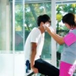 Caregiver tending to seated man by window