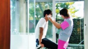 Caregiver tending to seated man by window