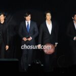 Four men in suits standing on stage