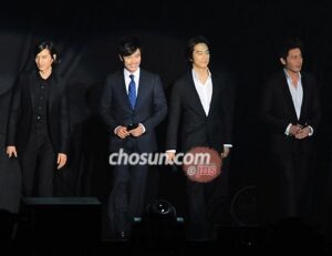 Four men in suits standing on stage