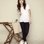 Woman in white t-shirt leaning on wooden table