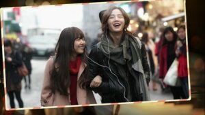 Two friends sharing headphones on busy city street