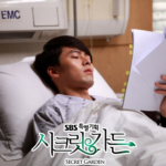 Man resting in hospital bed reading documents