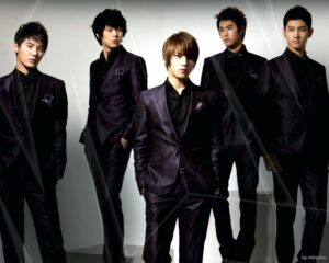 Five young men wearing black suits
