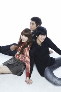 Three smiling young adults holding hands