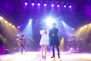 Duet singers performing on lit stage with confetti