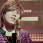 Singer in purple sequined jacket at microphone