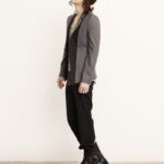 Model wearing gray blazer, black pants, boots