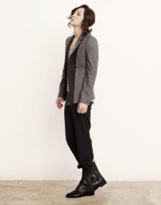Model wearing gray blazer, black pants, boots
