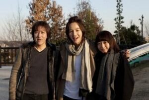 Three smiling people posing outdoors