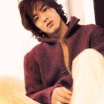 Young man wearing maroon sweater, seated