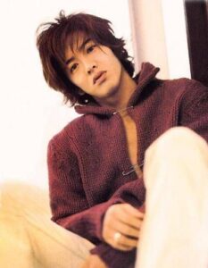 Young man wearing maroon sweater, seated