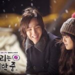 Young man smiling at companion in falling snow