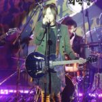 Singer performing with electric guitar on stage