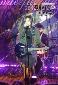 Singer performing with electric guitar on stage