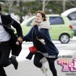 Couple running hand-in-hand on snowy street