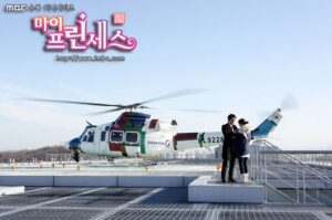 Helicopter on rooftop helipad with three people
