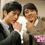Two men in suits posing with chin gestures