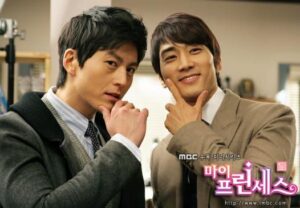 Two men in suits posing with chin gestures