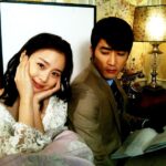 Smiling woman beside man reading papers