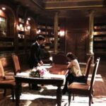 Ornate library interior with two people at table